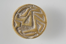Sceau en forme de bouton avec un personnage assis tenant un lotus