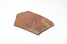 Fragment van schotel die met loofwerkmotieven versierd is