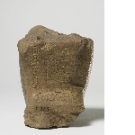 Fragment of the figurine of a squatting man, with inscription