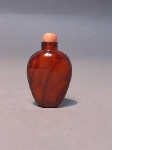 Oval amber snuff bottle with pink coral stopper